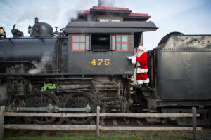 Santa is standing on Steam Train car #475.