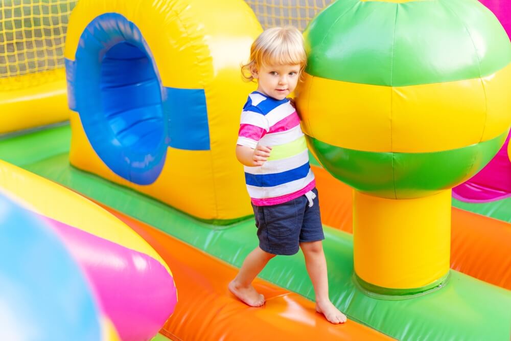 A toddler playing on an indoor bounce house.