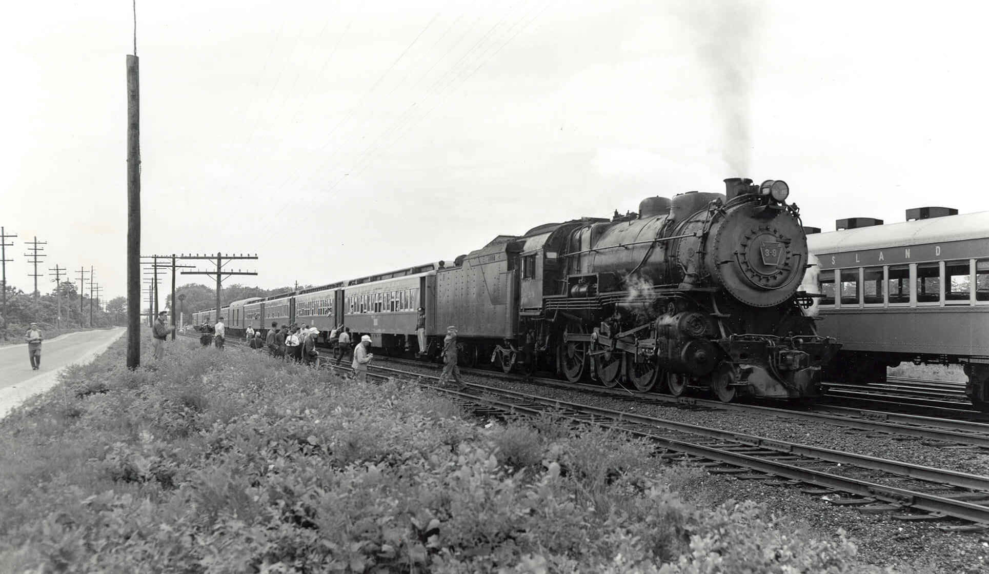 A historic steam engine train traveling down train tracks.