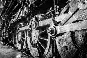 Close up black and white image of train wheels.