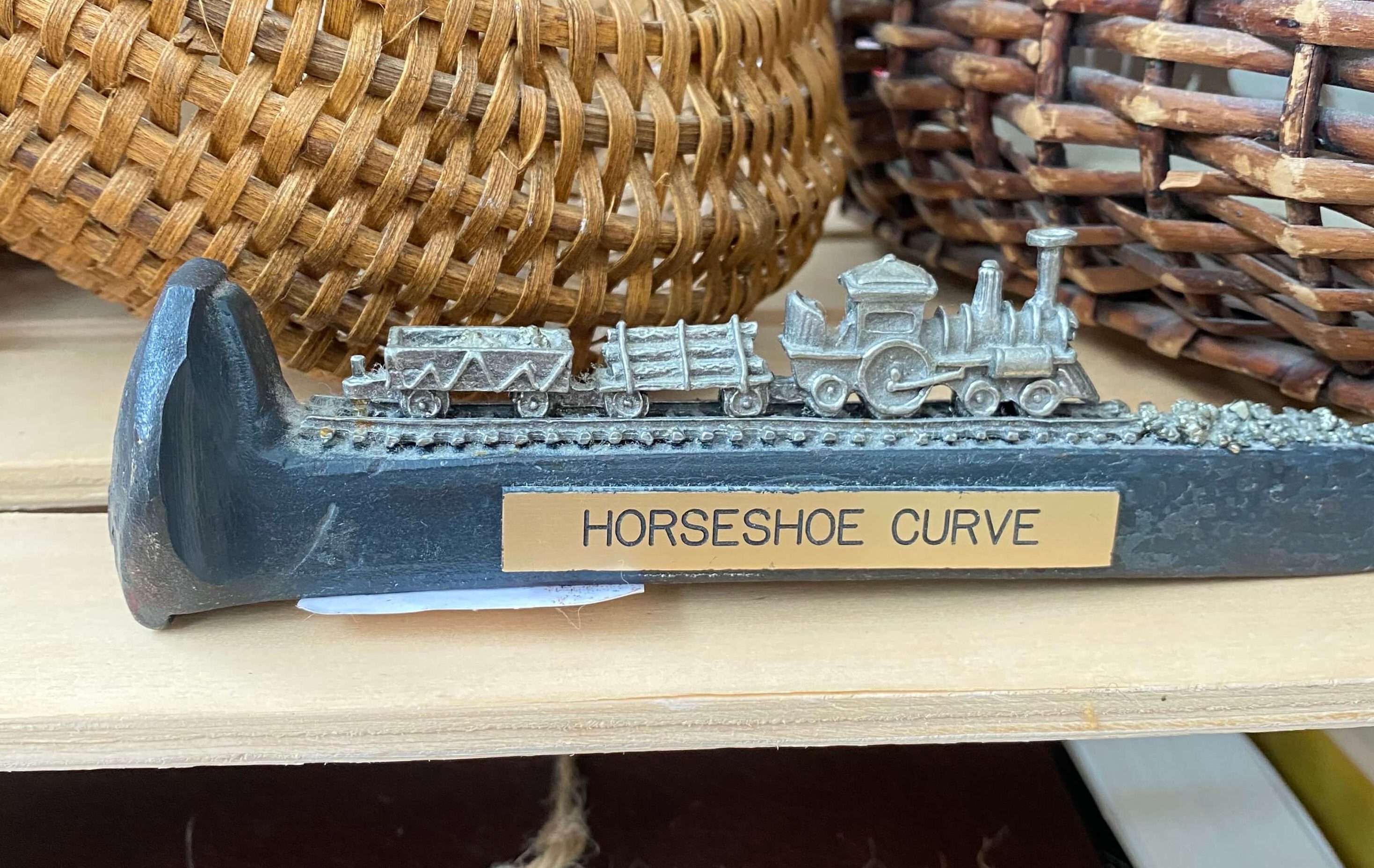 A railroad spike with a small metal train figurine on it, creating a bookend.