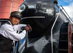 Strasburg Rail Road's train conductor standing in front of the 611 locomotive.